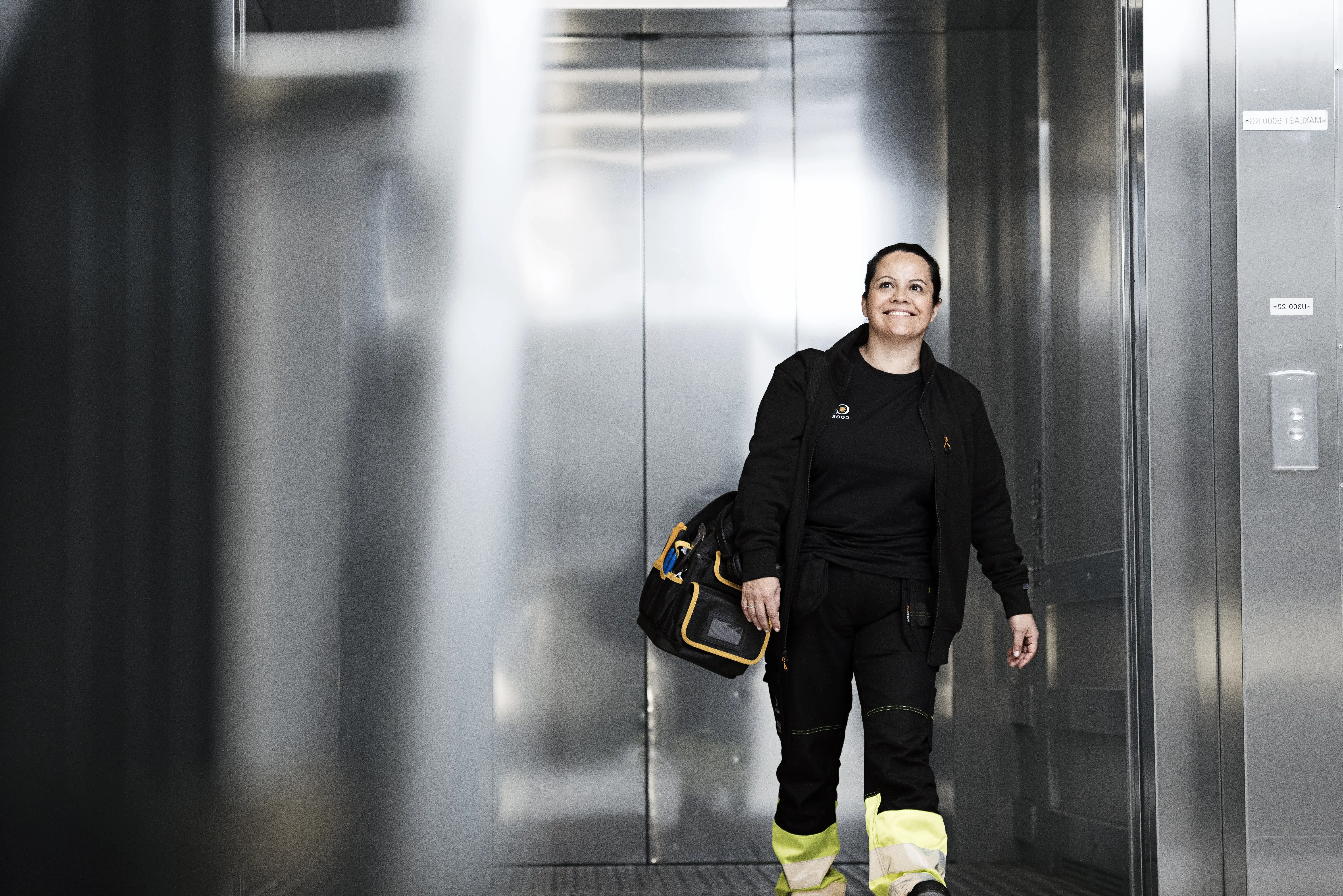 Smiling janitor exiting elevator.