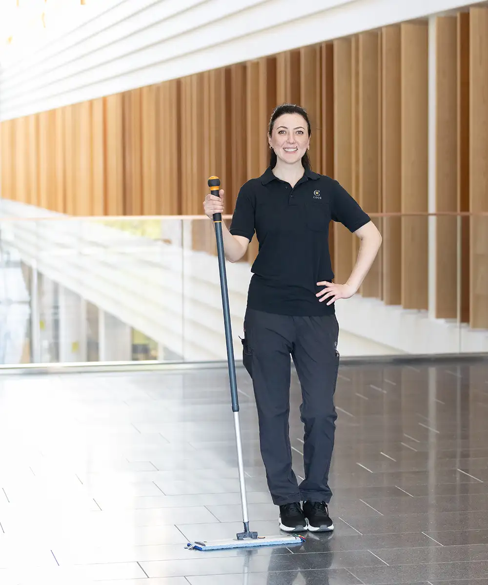 Female cleaning standing and holding a mop