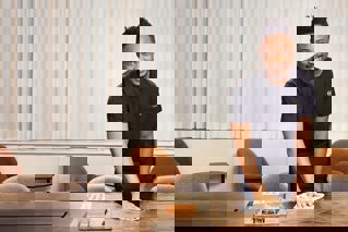 Leende vaktmästare som lämnar hissen.