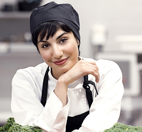 Chef leaning her elbows on a bench in a kitchen