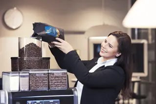 Receptionist refilling coffee beans