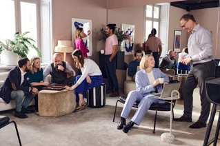 A group of people chatting in an office lounge area.