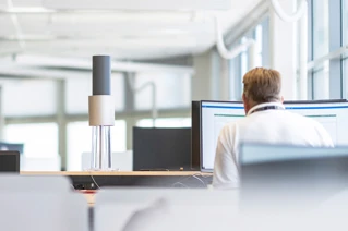 Office workers at computers in modern open-plan office space