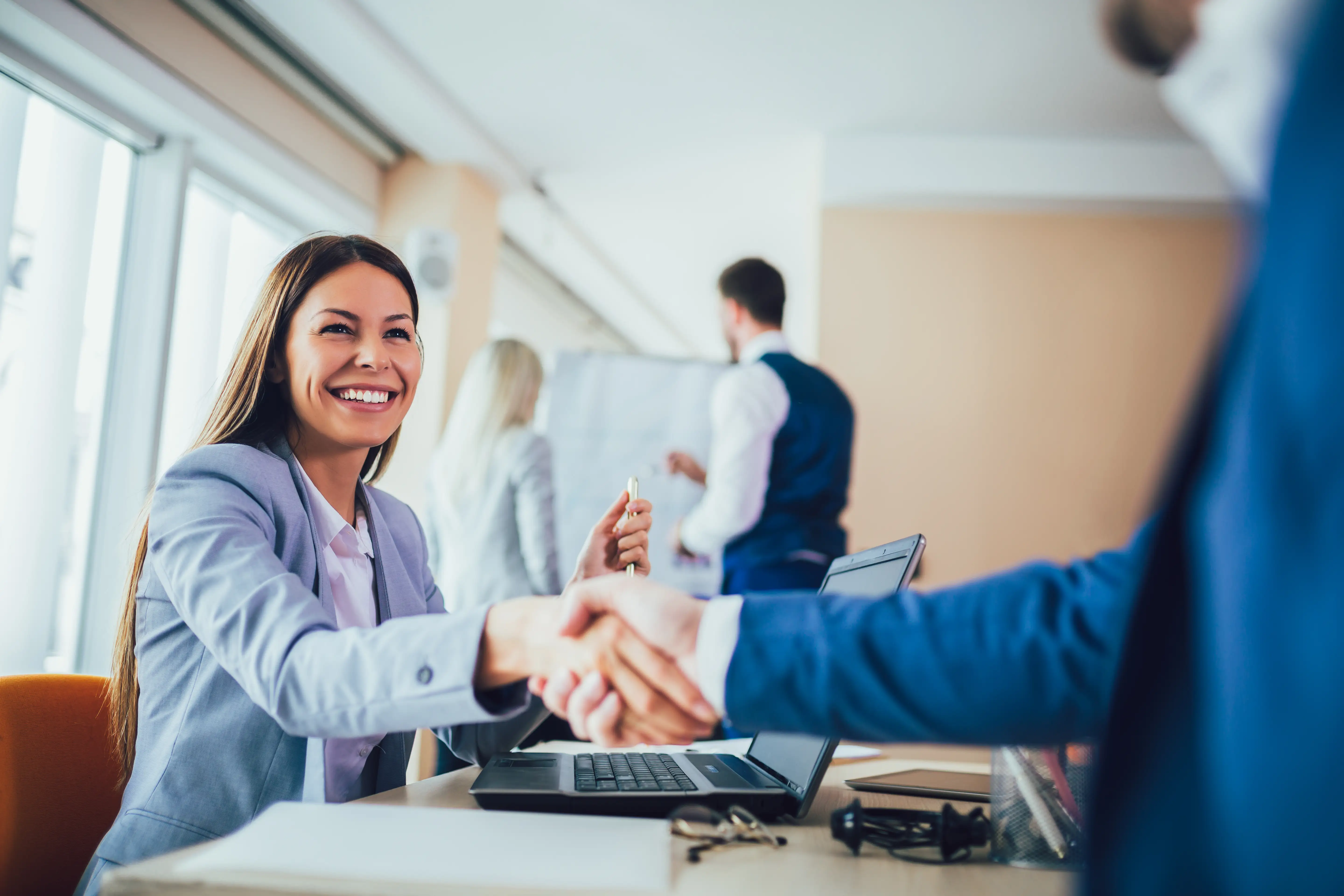 Business woman shaking hand with business partner after making an agreement